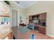 Functional home office space with a wooden desk, built-in shelves, and open access to the living area at 5359 90Th Avenue E Cir, Parrish, FL 34219