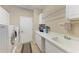 Well-lit laundry room showcasing a washer and dryer, with functional counter space, sink, and white cabinetry at 5359 90Th Avenue E Cir, Parrish, FL 34219