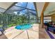 A serene screened-in pool area with a kidney-shaped pool, comfortable seating, and lush landscaping at 5359 90Th Avenue E Cir, Parrish, FL 34219