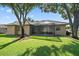 Exterior view of the backyard, showing the screened lanai and mature trees at 5584 Eastwind Dr, Sarasota, FL 34233