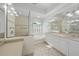 Bright bathroom featuring double vanity, soaking tub under a window, and separate glass-enclosed shower at 5584 Eastwind Dr, Sarasota, FL 34233