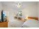 Bedroom with a ceiling fan, bright window, and mirrored closet offering ample natural light and storage at 5584 Eastwind Dr, Sarasota, FL 34233