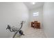Bright, tiled room with stationary bike, desk, printer, and natural light at 5584 Eastwind Dr, Sarasota, FL 34233