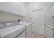 Well-lit laundry room with washer, dryer, cabinets, and sink at 5584 Eastwind Dr, Sarasota, FL 34233
