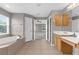 Primary bathroom with a soaking tub, vanity with a sink and an open doorway leading to a bedroom at 5981 Willows Bridge Loop, Ellenton, FL 34222