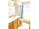 Bathroom with tiled floors, vanity, and shower with printed curtain at 5981 Willows Bridge Loop, Ellenton, FL 34222
