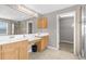 Bathroom featuring a dual sink vanity, a walk-in closet and a glass-enclosed shower, all with neutral tones at 5981 Willows Bridge Loop, Ellenton, FL 34222