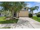Traditional two-story home featuring a two-car garage, manicured lawn, and columned front porch at 5981 Willows Bridge Loop, Ellenton, FL 34222