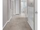 Hallway featuring carpet flooring, white trim, and doorways leading to various rooms, creating a cohesive flow at 5981 Willows Bridge Loop, Ellenton, FL 34222