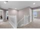 Upstairs landing with white railings leading to other rooms, offering a view of a well-lit, open-concept design at 5981 Willows Bridge Loop, Ellenton, FL 34222