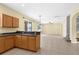 Open-concept kitchen with wood cabinetry, connecting to living area and stairway at 5981 Willows Bridge Loop, Ellenton, FL 34222