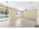 Open-concept living room with neutral paint, tile floors, and sliding glass doors to pool area at 5981 Willows Bridge Loop, Ellenton, FL 34222