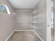 Walk-in closet featuring carpeted floor, shelving, and a view of the bathroom area with natural light at 5981 Willows Bridge Loop, Ellenton, FL 34222