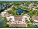 Residential complex from above, showcasing terracotta roofs and a scenic pond nearby surrounded by palms at 6101 34Th W St # 11C, Bradenton, FL 34210
