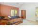 A bedroom with a sliding glass door to a balcony, tan carpet, and a wooden closet at 6101 34Th W St # 11C, Bradenton, FL 34210