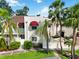Two-story condo with red awnings, a manicured lawn, and mature palms at 6101 34Th W St # 11C, Bradenton, FL 34210