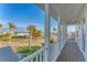 Balcony with white pillars overlooking a residential street with palm trees and glimpses of the nearby ocean at 634 Key Royale Dr, Holmes Beach, FL 34217