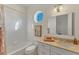 Bright bathroom with a bathtub, a round window, and neutral decor at 634 Key Royale Dr, Holmes Beach, FL 34217