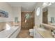 Bright bathroom with double vanity, shower, and soaking tub at 634 Key Royale Dr, Holmes Beach, FL 34217