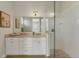 Well-lit bathroom features dual sconces, a large mirror, vanity with granite countertop, and a glass-enclosed shower at 634 Key Royale Dr, Holmes Beach, FL 34217