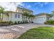 Beautiful two-story home with a two-car garage, tropical landscaping, and a brick driveway at 634 Key Royale Dr, Holmes Beach, FL 34217