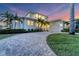 Charming two-story waterfront home featuring a paver driveway, lush landscaping, and inviting curb appeal at 634 Key Royale Dr, Holmes Beach, FL 34217