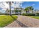 Charming two-story home boasts a brick driveway and lush tropical landscaping, creating a welcoming curb appeal at 634 Key Royale Dr, Holmes Beach, FL 34217