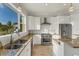 Bright kitchen features stainless steel appliances, granite counters, and a large window with tropical views at 634 Key Royale Dr, Holmes Beach, FL 34217