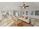 Bright living room featuring stylish furniture, tile floors, and an open layout leading to the kitchen and dining area at 634 Key Royale Dr, Holmes Beach, FL 34217