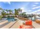 Inviting pool area with lounge seating, lush tropical landscaping, and scenic waterway views at 634 Key Royale Dr, Holmes Beach, FL 34217