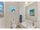 Stylish powder room with a modern sink, a round window, and coastal-themed decor at 634 Key Royale Dr, Holmes Beach, FL 34217