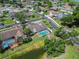 Aerial view of a home with a screened-in pool, landscaped yard and nearby pond within a neighborhood at 6405 Alesheba Ln, Sarasota, FL 34240