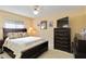 Cozy bedroom featuring a dark wood bed frame, ceiling fan, and a large dresser at 6405 Alesheba Ln, Sarasota, FL 34240