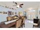 Elegant dining room with a large wood table and seating for six under a ceiling fan light fixture at 6405 Alesheba Ln, Sarasota, FL 34240