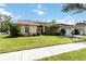 A well-maintained single-Gathering home with a green lawn and mature landscaping under a blue sky at 6405 Alesheba Ln, Sarasota, FL 34240