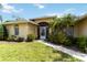 A welcoming front entrance with a screened porch, lush landscaping, and a well-maintained lawn at 6405 Alesheba Ln, Sarasota, FL 34240