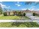 Charming single-story home with a well-manicured lawn, palm trees, and attached two car garage at 6405 Alesheba Ln, Sarasota, FL 34240