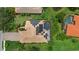 Aerial view of a home featuring a solar panel roof, screened pool, and lush landscaping at 6528 Coopers Hawk Ct, Lakewood Ranch, FL 34202