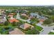 Aerial view of a charming neighborhood featuring homes, ponds, and lush landscaping at 6528 Coopers Hawk Ct, Lakewood Ranch, FL 34202