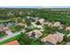 Aerial view of a well-maintained neighborhood with ponds, mature trees, and varied roof styles at 6528 Coopers Hawk Ct, Lakewood Ranch, FL 34202