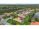 Aerial view of a quiet neighborhood with well-maintained homes, greenery, and a serene pond at 6528 Coopers Hawk Ct, Lakewood Ranch, FL 34202