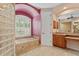 Elegant bathroom with a soaking tub, glass block accent, and a vanity with ample counter space at 6528 Coopers Hawk Ct, Lakewood Ranch, FL 34202