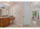 Bathroom with a vanity area, wooden cabinets, granite counters, and a large mirror at 6528 Coopers Hawk Ct, Lakewood Ranch, FL 34202