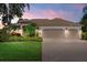 Charming single-story home with a well-maintained lawn, beautiful landscaping, and a beige tile roof at 6528 Coopers Hawk Ct, Lakewood Ranch, FL 34202
