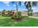Beautifully landscaped home featuring a lush green lawn, mature trees, and a charming front facade at 6528 Coopers Hawk Ct, Lakewood Ranch, FL 34202
