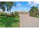 Landscaped front exterior featuring a tile roof and a spacious three-car garage at 6528 Coopers Hawk Ct, Lakewood Ranch, FL 34202