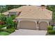 Charming home featuring a tile roof, lush landscaping, and a spacious two-car garage at 6528 Coopers Hawk Ct, Lakewood Ranch, FL 34202