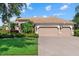 Charming home featuring a tile roof, lush landscaping, and a spacious three-car garage at 6528 Coopers Hawk Ct, Lakewood Ranch, FL 34202