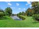 Community pond provides a scenic backdrop with lush greenery and beautiful sky at 6528 Coopers Hawk Ct, Lakewood Ranch, FL 34202