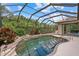 Private pool features a screen enclosure and tropical landscaping with lush plants at 6528 Coopers Hawk Ct, Lakewood Ranch, FL 34202